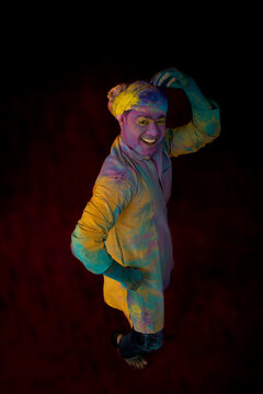Man with gulal on his face dancing in excitement on Holi