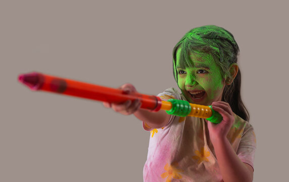 Young girl playing with a pichkari on holi