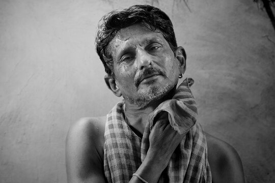 A farmer wiping off his sweat with a red cloth