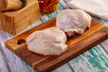 Raw chicken thighs on a wooden cutting board ready for cooking © Andrei Starostin