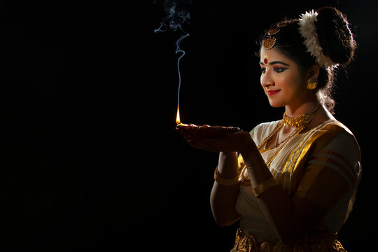 Mohiniattam dancer holding g a Diya in her hand before starting her performance