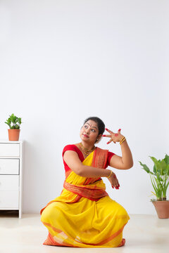 Kuchipudi dancer sitting in Alapadma and dola mudra practicing  at home
