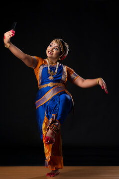 Kuchipudi dancer clicking a selfie on her phone while dancing