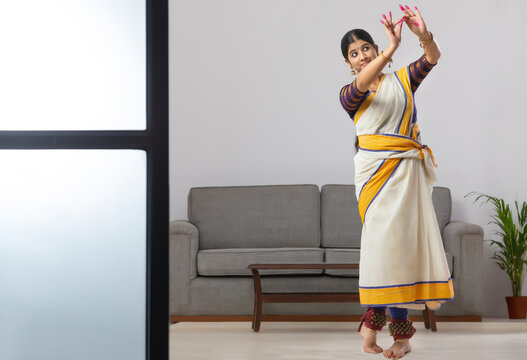 Woman in South Indian saree practicing Mudrakhya showing the depiction of her decorating her house