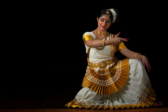 Mohiniattam dancer sitting with her hand in front in Ardhachandra mudra