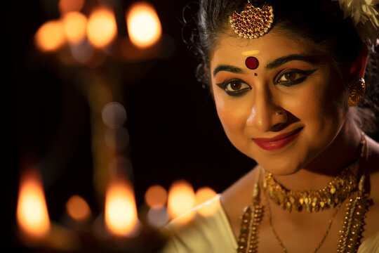 Mohiniattam dancer smiling in front of a lamp