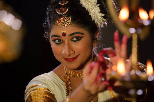 Mohiniattam dancer in Mudrakhya mudra of lighting a lamp