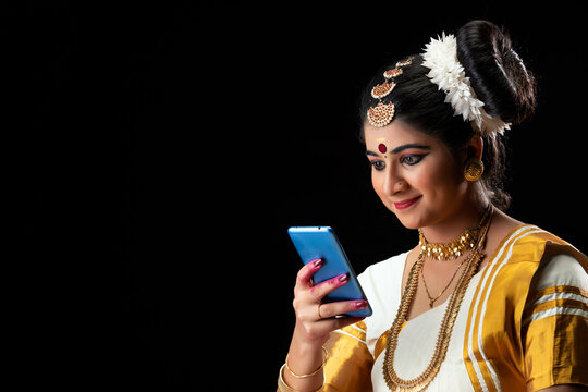 Mohiniattam dancer smiling while texting on phone