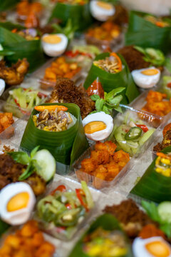 Traditional Indonesian Nasi Tempong rice boxes served with fried chicken, boiled egg, sambal, vegetables and banana leaf presentation. Ideal for catering, takeaway and authentic Asian cuisine.
