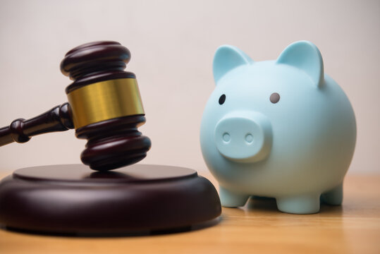 Hammer judge gavel and blue piggy bank on wooden table white wall background. Spending money for bail, bankruptcy judgement, borrower has financial problem can not repay and so on concept.