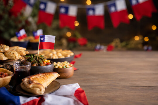Chilean feast with empanadas and pebre sauce for Fiestas Patrias. Authentic table setting with copy space.