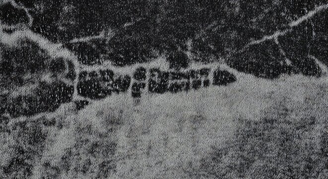 Black and white aerial view of a train on a rural track.