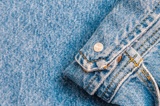 Blue denim jacket cuff texture background with copy space.