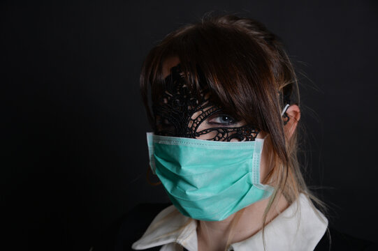 Dramatisches Low-Key-Portr&auml;t einer Frau mit medizinischer Gesichtsmaske. Symbolbild f&uuml;r Gesundheit, Infektionsschutz, Pandemie, Atemschutz, Hygiene, Medizin und Pr&auml;vention.