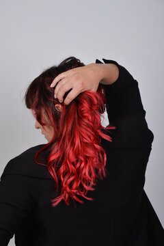 Portr&auml;t einer Frau mit leuchtend roten Haaren von hinten. Stilvolle Beauty-Aufnahme zu Haarpflege, Frisur, Coloration, Selbstbewusstsein, moderner &Auml;sthetik und Lifestyle.