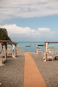 Pebble beach with wooden walkway leading to the turquoise sea and