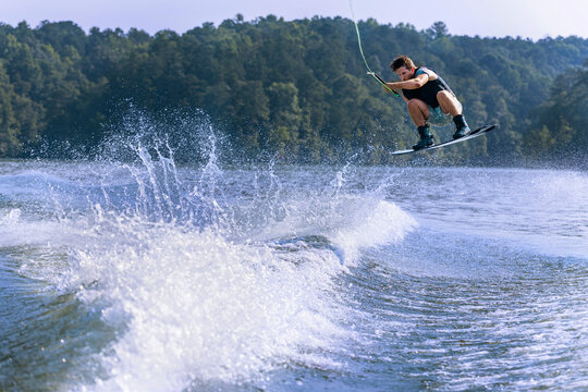 A young man is wakeboarding on a lake.