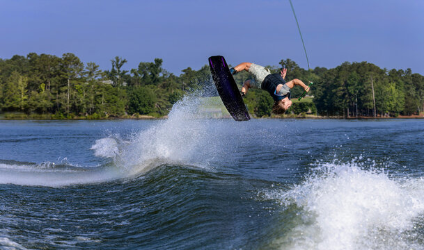 A young man is wakeboarding on a lake.