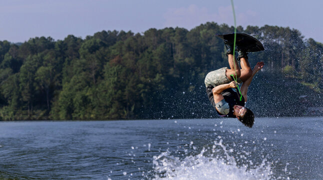 A young man is wakeboarding on a lake.
