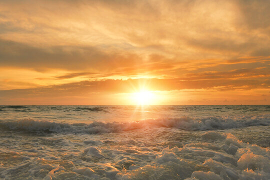 Beautiful golden sun setting over ocean waves