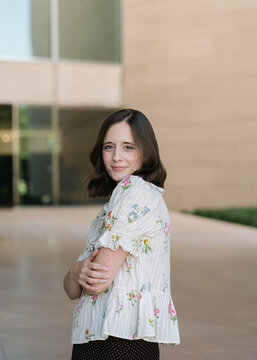 Friendly woman in floral top looking at camera