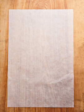 Blank parchment paper on rustic wooden table, ideal for baking and cooking preparations