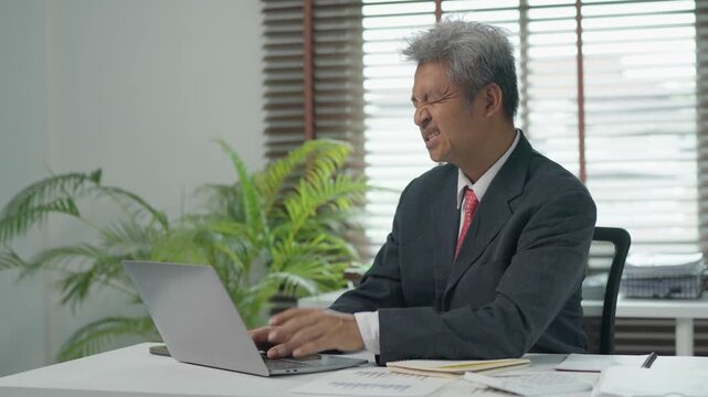 Stressed businessman suffering from neck pain at his desk