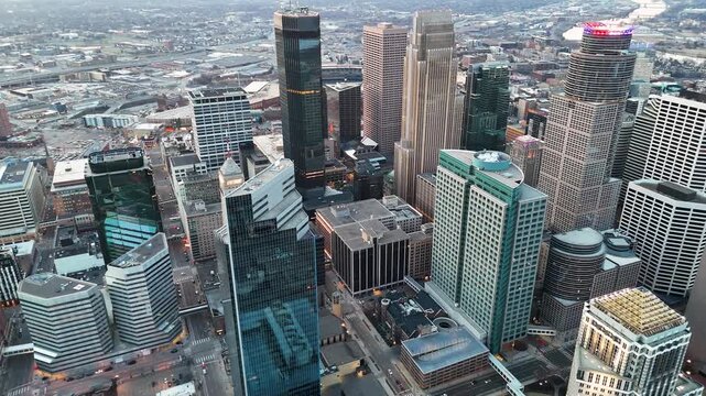Cinematic drone footage of the downtown skyline in Minneapolis, Minnesota, USA, showcasing modern skyscrapers, commercial buildings, urban streets, and the vibrant metropolitan atmosphere