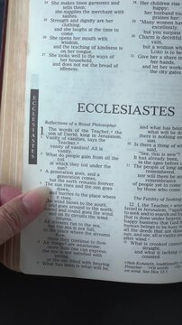 Opening to the Book of Ecclesiastes of the Old Testament in the Holy Bible. New Revised Standard Version. Vertical video.