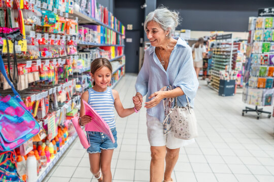 Grandmother and granddaughter shopping for school supplies together