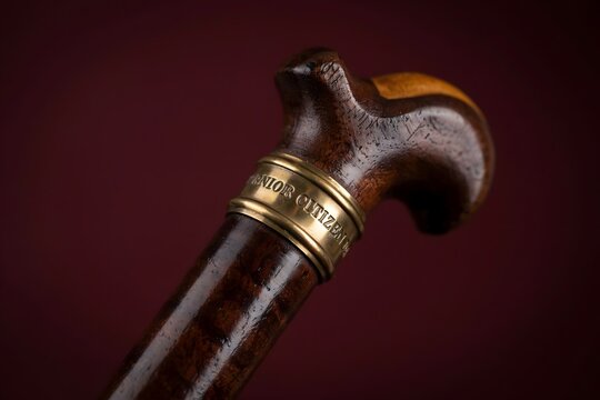Elegant wooden walking cane handle close-up with walking aid, old fashioned