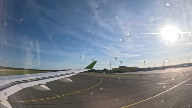 RIGA, LATVIA - JULY 1, 2024: airBaltic airplane taxiing on airport tarmac on a bright sunny day