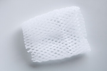 Fototapeta premium Detailed shot of a flexible white mesh foam sleeve used for packaging and protecting delicate fruit.