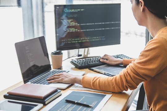 Young Professional programmer working at developing programming and website working in a software develop company office, writing codes and typing data code, Programming with HTML, PHP and javascript