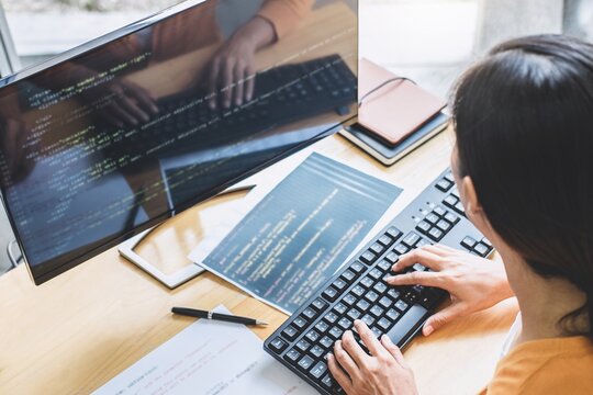 Young Professional programmer working at developing programming and website working in a software develop company office, writing codes and typing data code, Programming with HTML, PHP and javascript