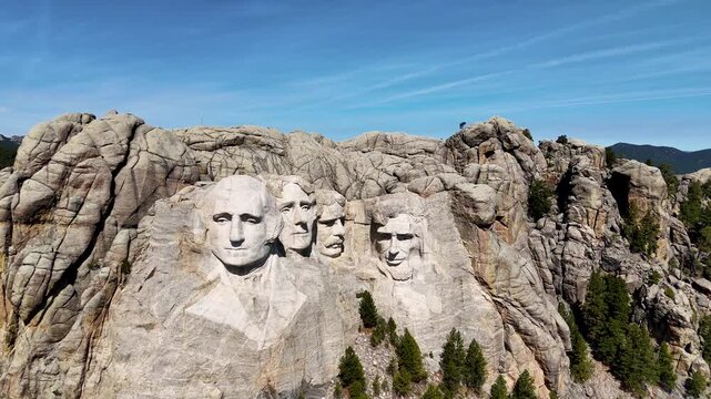 Cinematic drone footage of Mount Rushmore National Memorial in South Dakota, USA, showcasing the monumental granite sculptures of four American presidents surrounded by the scenic Black Hills