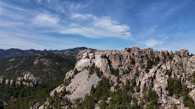 Cinematic drone footage of Mount Rushmore National Memorial in South Dakota, USA, showcasing the monumental granite sculptures of four American presidents surrounded by the scenic Black Hills