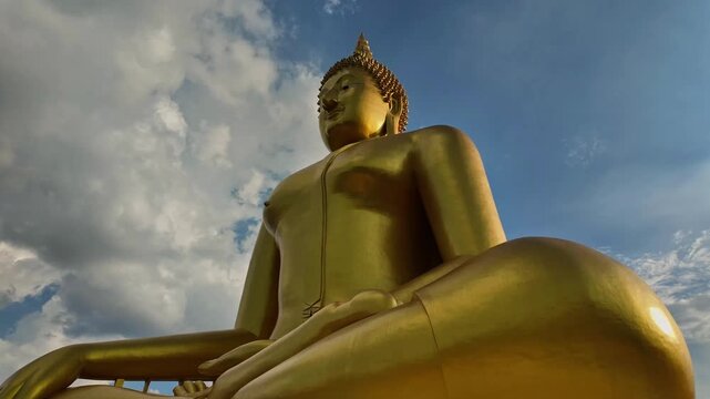 Panoramic timelapse tilt-up of the Giant Buddha of Ang Thong, Thailand's tallest Buddha, with clouds in the background