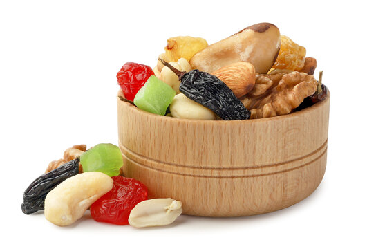 Mix of nuts and dried fruits in a wooden bowl on a white background. Isolated