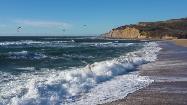 Drone hover over surf then slow backward track