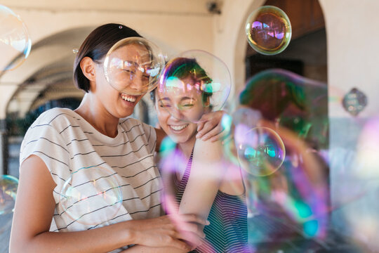 Two young women playing with soap bubbles