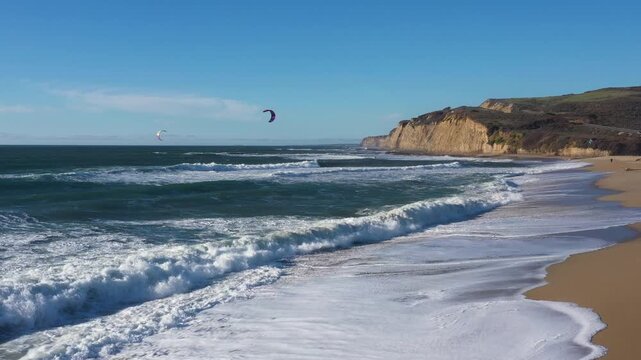 Midday drone beach to waves three kitesurfers
