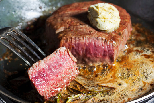 Fried fillet of beef with herb butter, peppercorns and rosemary in a pan