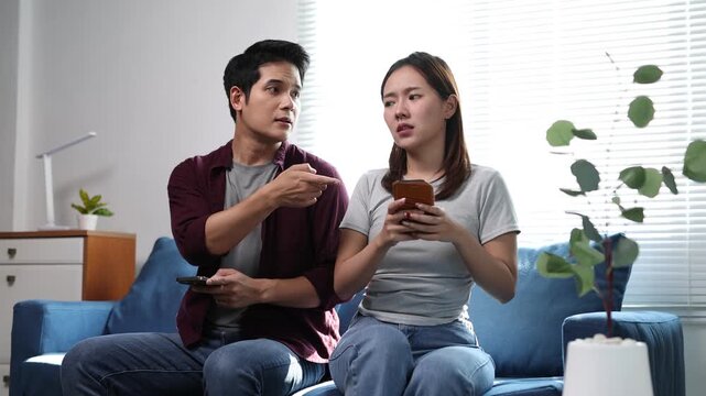 A couple had an argument over their cell phones while sitting on the sofa in the living room.