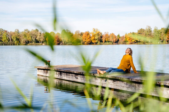 Woman relaxing on sunny day at jetty
