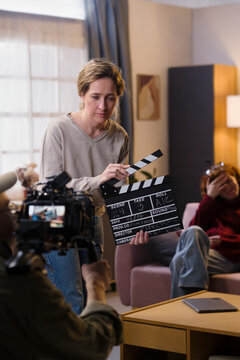Female crew member holds a clapperboard on a film set