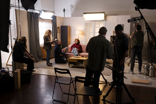 A film crew shoots a movie scene with an actress indoors