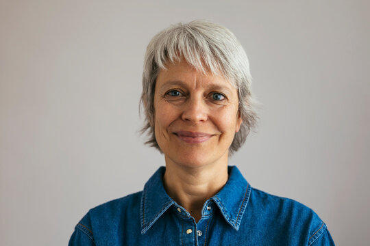 Smiling mature woman against gray background