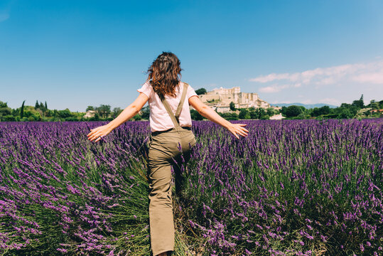 France, Grignan, back view of woman crossing lavender field