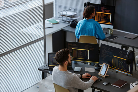 IT professional with colleague working on desktop at desk